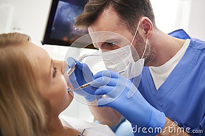 Focused stomatologist treating woman for dental cavity Stock Photo