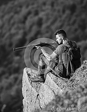 Focused on target. Hunter hold rifle. Hunter spend leisure hunting. Man brutal gamekeeper nature landscape background Stock Photo