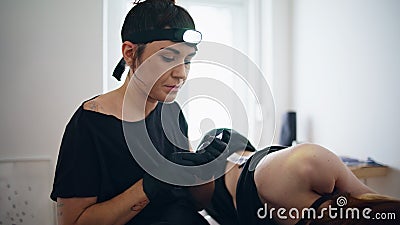 Focused tattooist holding machine at home closeup. Woman changing consumable Stock Photo