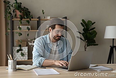 Focused young businessman freelancer engaged in distant work on laptop Stock Photo