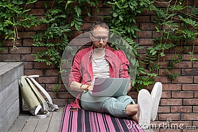 Focused young businessman freelancer engaged in distant work from street make report on laptop Stock Photo