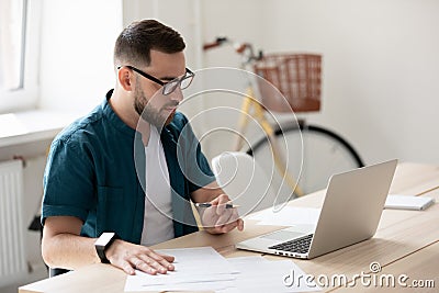 Focused male employee make notes watching webinar Stock Photo