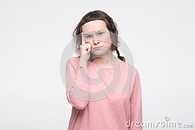 Focused young woman in pink clothes with attractive look tries to remember something in mind Stock Photo