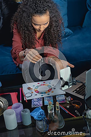 Focused young woman using a crystal pendulum Stock Photo