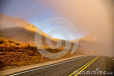 Fog in the extreme dry desert terrain of Lindis Mountain Pass in New Zealand Stock Photo