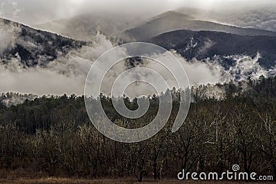 Fog floats around the mountains and fields of Cades Cove. Stock Photo