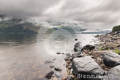 Fog on the mountains and loch in Scotland highlands after the ra Stock Photo