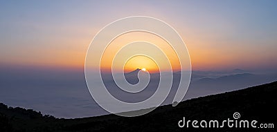 Fog in mountains. White wavy fog at the sunrise. landscape of mountains with the sun Stock Photo