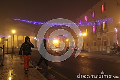 Foggy night scene. People walking on the streets of Foggia decorated with christmas lights Editorial Stock Photo