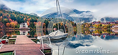 Foggy autumn view of Grundlsee lake with small yacht. Amazing morning scene of Brauhof village, Styria stare of Austria, Europe. Stock Photo