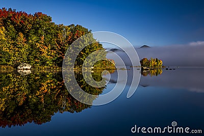 Foggy Lake and Green Mountains - Island with Colorful Trees - Autumn / Fall - Vermont Stock Photo