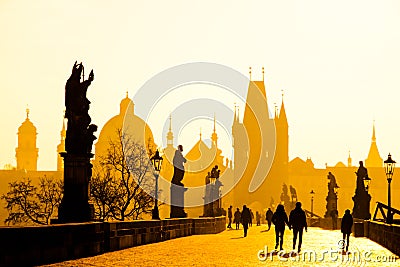 Foggy morning on Charles Bridge, Prague, Czech Republic. Sunrise with silhouettes of walking people, statues and Old Stock Photo