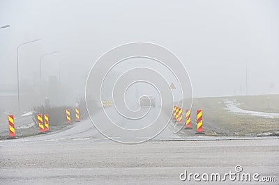 foggy road with roadwork signs and car Stock Photo