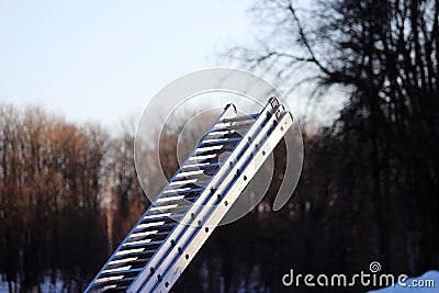 foldaway metal ladder in the park in the winter for work at height. Stock Photo
