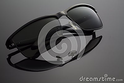 Folded Black Sunglasses on Black Background Stock Photo