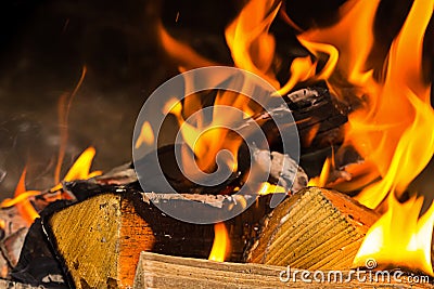 Folded bonfire firewood part of a solid log bright orange bright flame closeup background base home cosiness Stock Photo