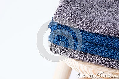 Folded cotton terry towels washcloth on wooden chair on white background. Laundry reusable eco friendly materials body care Stock Photo