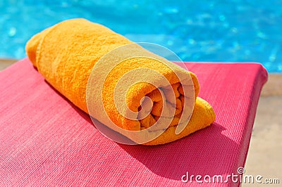 Folded orange towel on the background of the pool Stock Photo