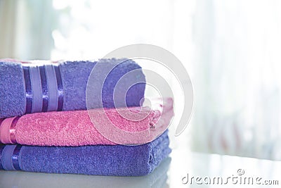 Folded purple and pink towels on a light background Stock Photo