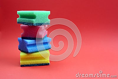 Folded scouring sponges in a single stack on a red background. Stock Photo