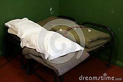 Folded sheets and blankets in a vintage military army barracks Stock Photo