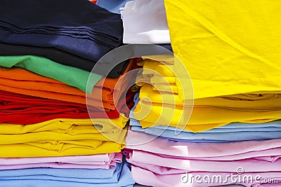 Folded t-shirts different colours. Sportswear in the store. fabrics Stock Photo