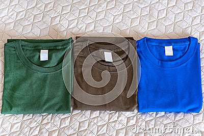 Folded t-shirts different colours. Sportswear in the store Stock Photo