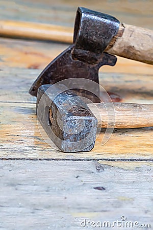Folded tools sledgehammer ax black old weathered on wooden base close-up Stock Photo