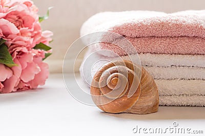 Folded towels on bathroom counter with flowers Stock Photo