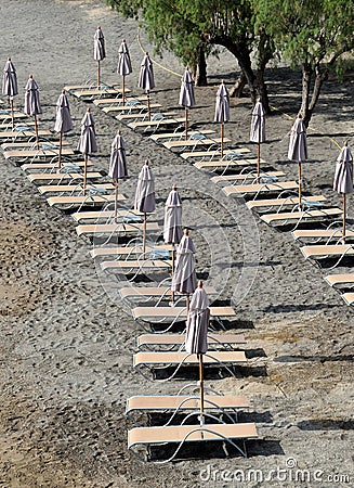 Folded Umbrellas on the Empty Beach Stock Photo