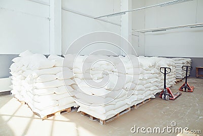 Folded white bags on pallets in factory storage. Stock Photo