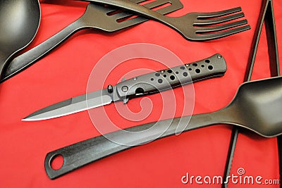 Folding knife stainless steel sharp blade red background black flatware Stock Photo