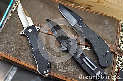 Folding knives on leather retro bag tablet in rarity store Stock Photo