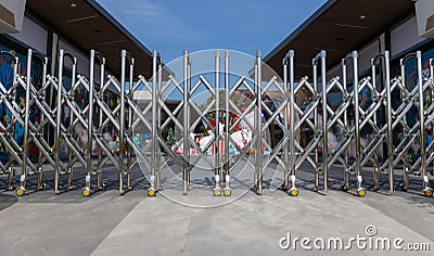 Folding retractable fence on casters. barrier on casters. Sliding gates on rollers. Pedestrian barrier. Barricade Gate. Lockdown Stock Photo