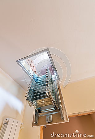 Folding staircase to attic room Stock Photo