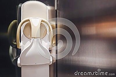 Folding toddler safety chair mounted on wall in public restroom Stock Photo