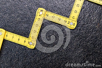 Folding zig zag ruler. Measuring tape folding yellow open in zigzag tips on a workbench. Measuring tools for carpenters and Stock Photo