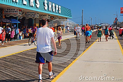 Folks enjoy the summerâ€™s warm weather on the boardwalk Editorial Stock Photo