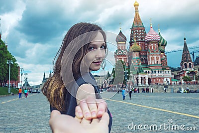 Follow me, Attractive brunette girl holding the hand leads to the red square in Moscow. Russia. Stock Photo