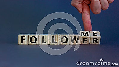 Follow me. Male hand turns wooden cubes and changes the words `follower` to `follow me`. Beautiful grey background, copy space Stock Photo