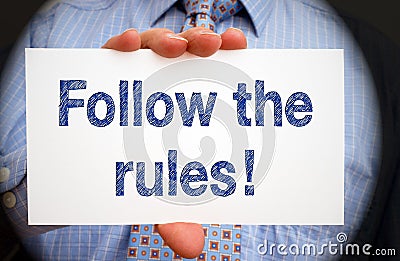 Follow the rules - Manager holding sign with text Stock Photo