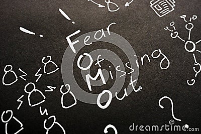 FOMO - Fear Of Missing Out sign on black sheet Stock Photo