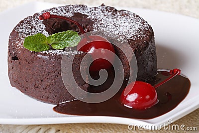 Fondant chocolate cake with cherries and mint on a dish Stock Photo