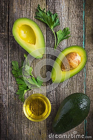 food background with fresh organic avocado, lime, parsley and olive oil Stock Photo