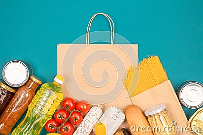 Food bank, food delivery concept. Paper bag with food donations on green background with copy space - pasta, fresh Stock Photo