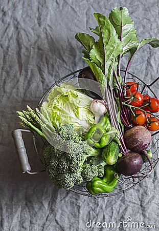 Food basket with fresh organic garden vegetables - beets, broccoli, eggplant, asparagus, peppers, tomatoes, cabbage on a grey tabl Stock Photo