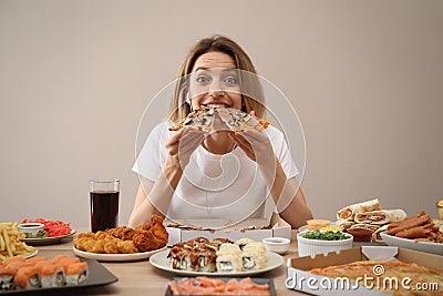 Food blogger eating at table against beige background. Mukbang vlog Stock Photo