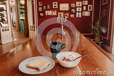 Food for breakfast at historical home. Dinning table with granola, yogurt, toast and hot coffee Stock Photo