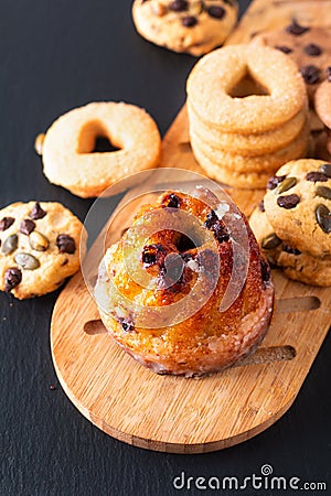 Food Breakfast or snack concept european Gugelhupf, Kougelhopf, kouglof yeast Bundt ring cake with cookies on black background Stock Photo