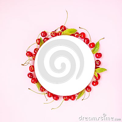 Food circle frame of red ripe cherries with green mint leaves on a pink background. View from above. Flat lay Stock Photo